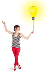 Happy woman holding a light bulb balloon