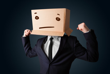 Businessman gesturing with a cardboard box on his head with stra