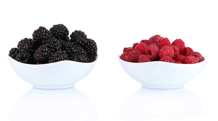 Ripe raspberries and blackberries in bowl isolated on white