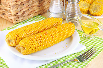 Flavored boiled corn on  plate on wooden table close-up