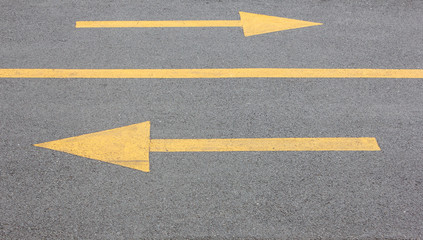 Yellow arrow right and left on asphalt steert road