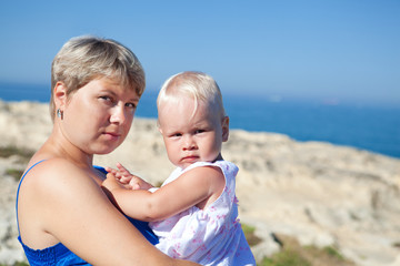 Happy mother and his little daughter at beach