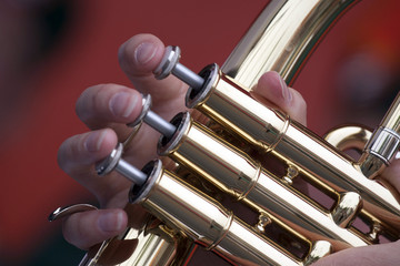 Three Fingers on the keys of a brass wind instrument