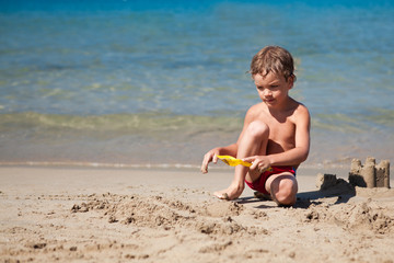 Boy making sand castle on beach