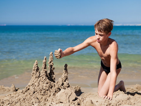 Boy making sand castle on beach