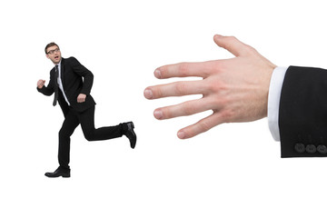 Running from big hand. Terrified young businessman running from