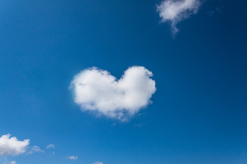 Naklejka na ściany i meble Heart shaped cloud in the blue sky background.
