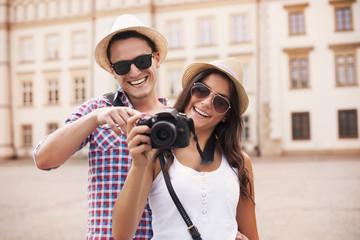 Smiling couple viewing pictures on the camera