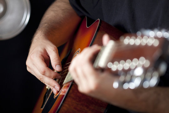 Close up on  hands playing guitar