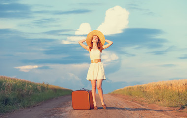 Redhead girl with suitcase at outdoor.