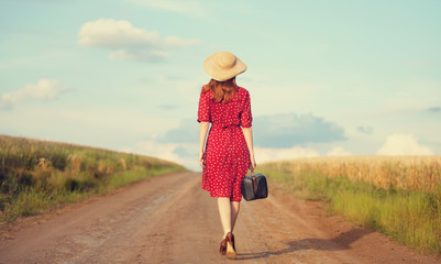 Redhead girl with suitcase at outdoor.