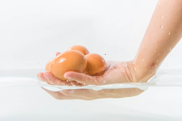 Eggs in hand into clear water splash