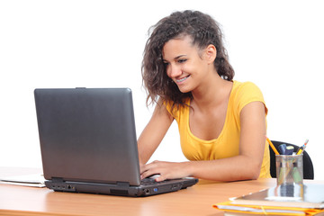 Teenager girl browsing on a laptop in the desk