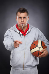 Displeased trainer. Portrait of angry young coach whistling and