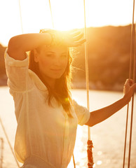 Beautiful woman on yacht on sunset