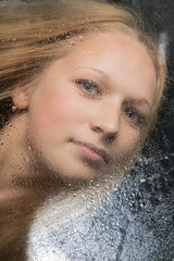 Portrait of the girl behind glass