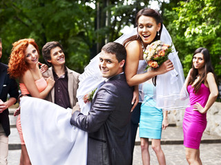 Groom carries his bride over shoulder.