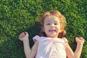 Little girl resting in fresh spring grass