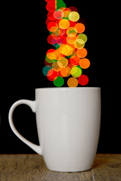 Bokeh round spots of lights on background cup on wood