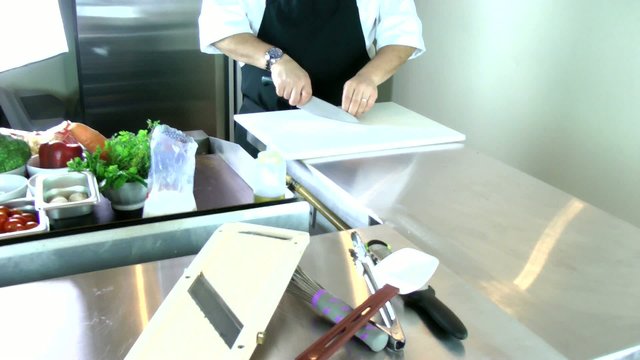 chef cutting garlic in a professional kitchen