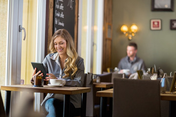 Pregnant Woman Using Digital Table In Cafe