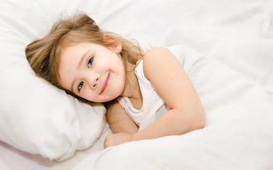 Adorable little girl awaked up in her bed