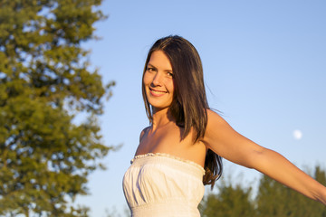 Naklejka premium woman standing in wheat field at sunset