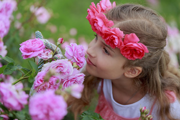 Rose garden - cute girl playing in the rose garden