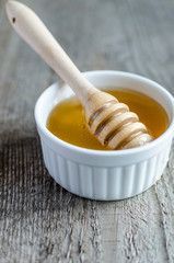 Honey bowl with dipper and flowing honey