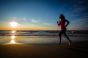 Fototapeta na wymiar Teenage girl running, jumping on beach