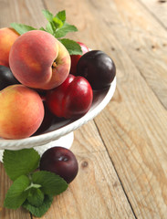 Naklejka na ściany i meble Fresh peaches, nectarines and plums in vase