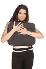 Fototapeta premium Beautiful young business woman hugging her laptop bag