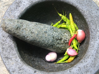 Chili pepper and shallots in stone mortar, Thai food cooking