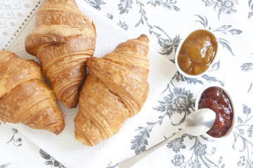 Croissants on table with jam, orange juice and coffee