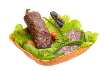 Ripe salami with salad, basil, onion and tomato