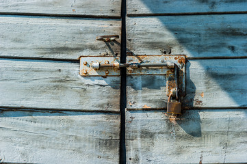 Rusty padlock on an old wooden door