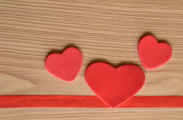 Tres corazones sobre fondo rústico de madera