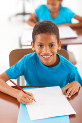 african schoolboy writing classwork