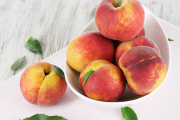 Peaches in plate on napkin on wooden table