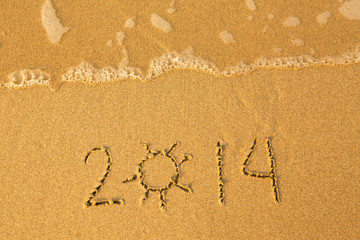 2014 - written in sand on beach texture - soft wave of the sea.