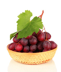 Ripe delicious grapes in wicker basket isolated on white