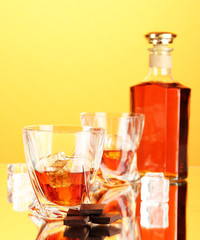 Bottle and two glasses of scotch whiskey, on color background