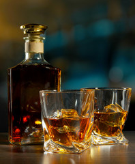 Glass of whiskey with bottle, on dark background