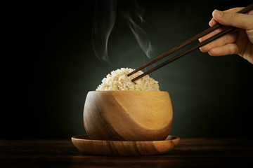 Cooked organic basmati brown rice with steam and chopsticks