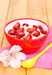 Cottage cheese in red bowl with sliced strawberries