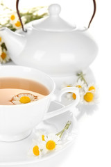 Cup of herbal tea with camomiles close up