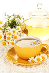 Cup of herbal tea with camomiles close up