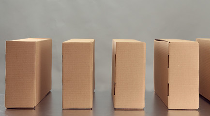 Cardboard boxes on conveyor belt, on grey background