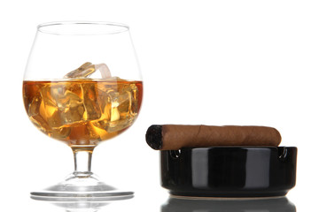 Brandy glass with ice and cigar isolated on white