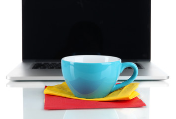 Blue cup on napkin on laptop background isolated on white